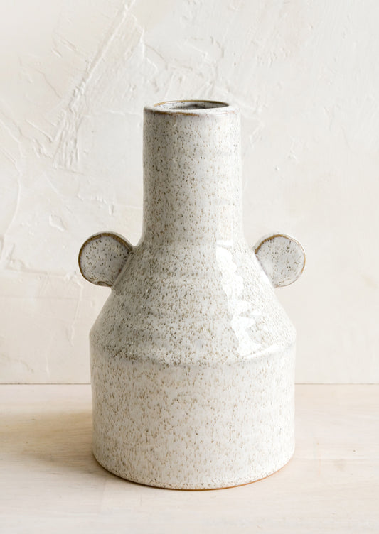 A ceramic vase in glossy sand speckle glaze with round decorative tabs at sides.