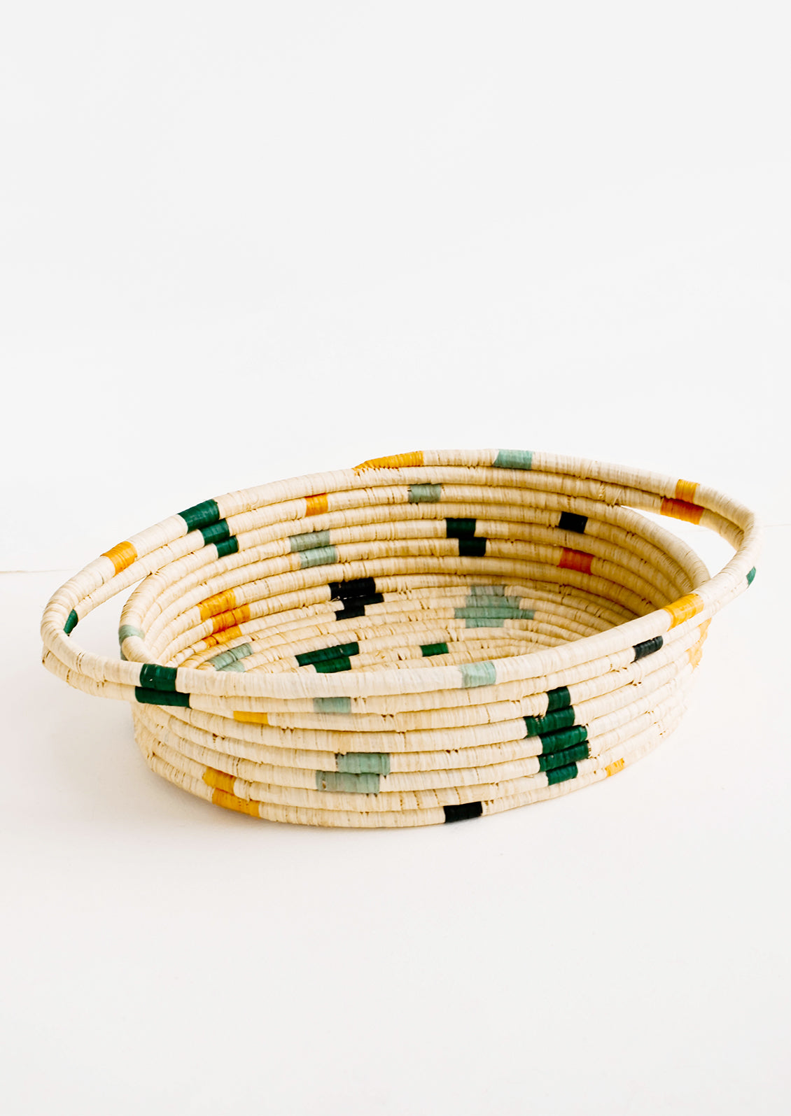 Oval shaped, woven raffia basket with terrazzo inspired print in shades of green