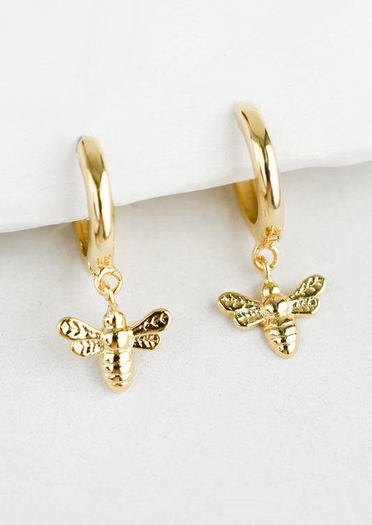 Gold huggie hoops with bee charm.