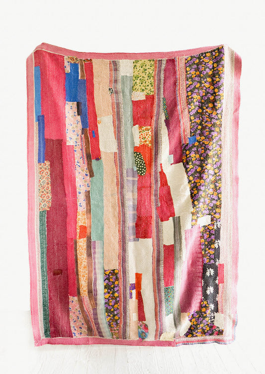 Vintage patchwork quilt in a mix of colors and fabrics. Predominantly magenta, brown and ivory.