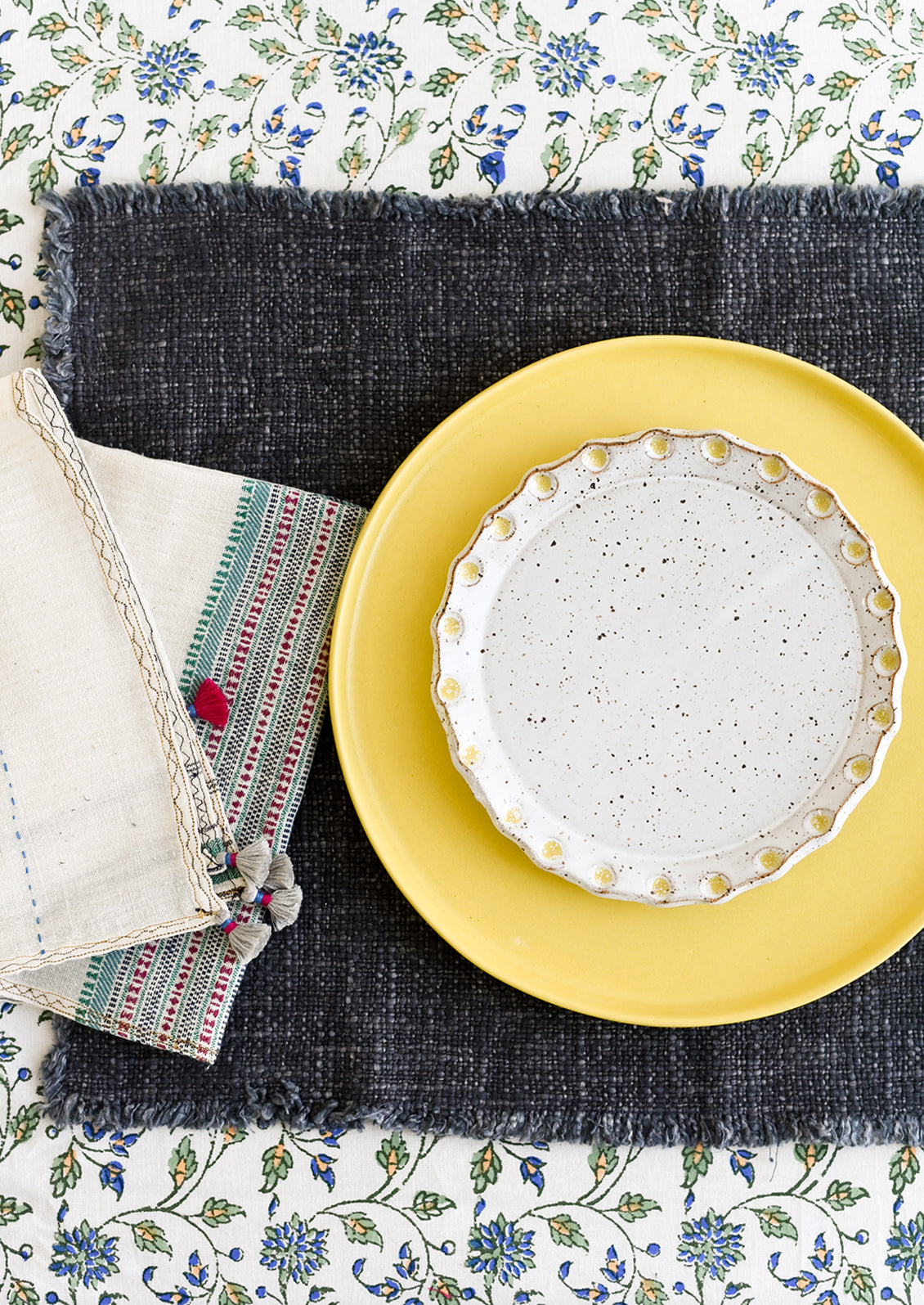 A table setting with plate and table linens.